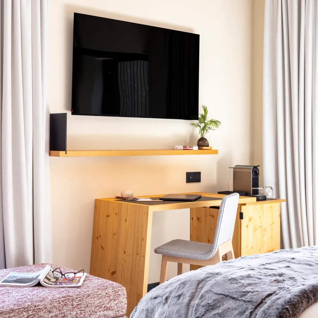 Chambre avec un lit, une table de travail en bois, un téléviseur et une machine à café